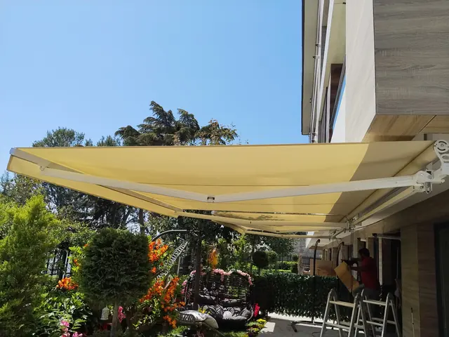 Bahçede sarı mafsallı tente